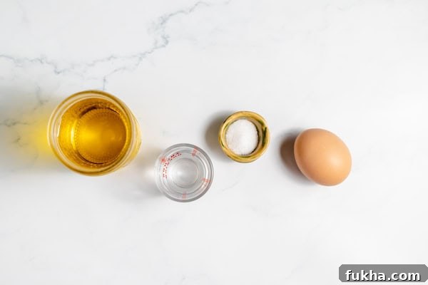 Image, taken from above shows small dishes with the ingredients needed for making homemade mayonnaise