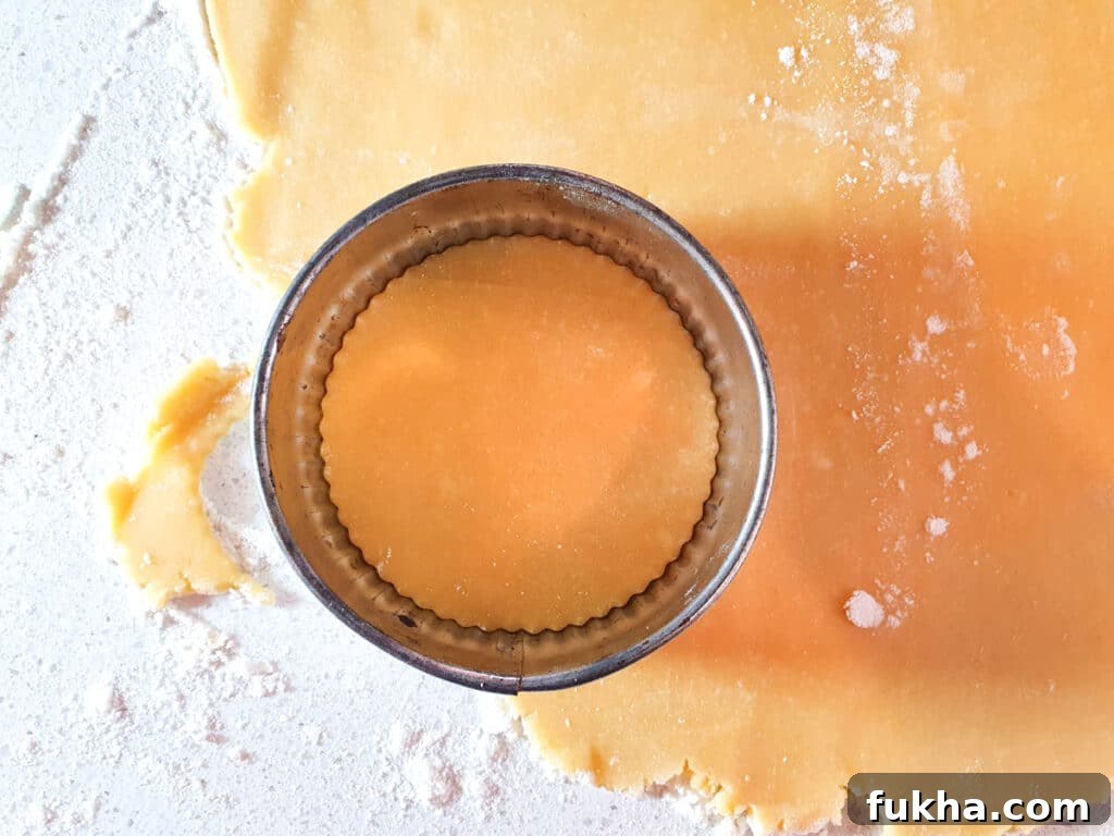 Cutting out tartlet shapes with a crinkled pastry cutter.