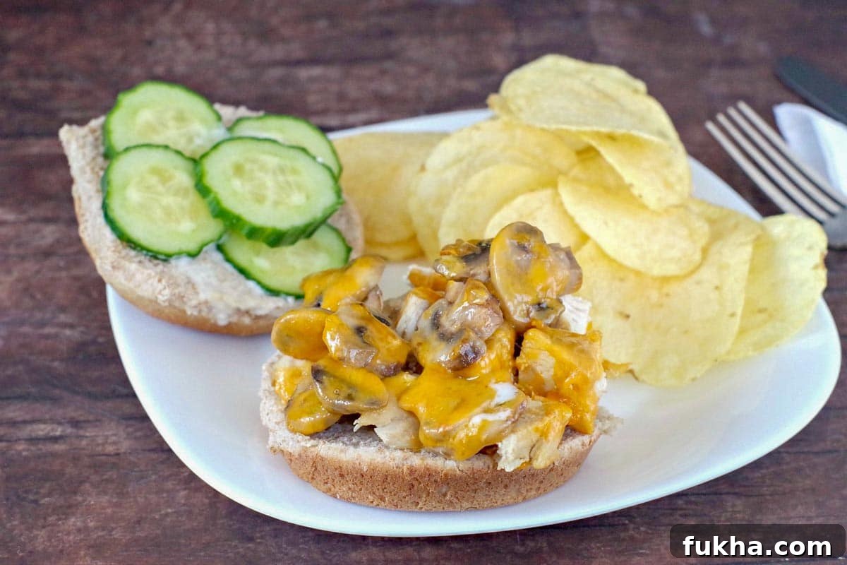 Juicy Grilled Chicken Breast Burger Recipe 4 healthy chicken burger on a plate, open-faced with potato chips on the side