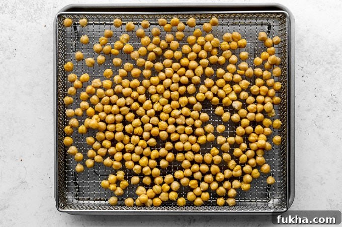 Chickpeas arranged on an air fryer basket.