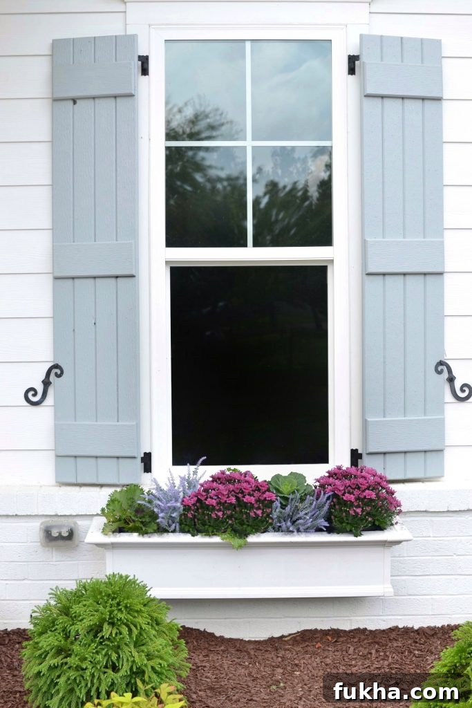 Artificial Window Box Flowers with purples and blues on a house
