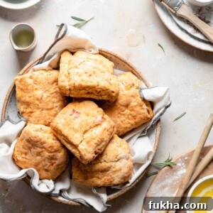 Bowl full of cheddar biscuits with melted butter.