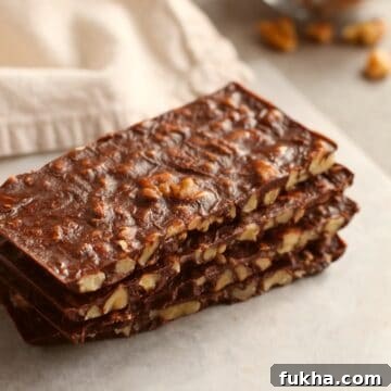 rectangular shaped sliced bars stacked on top of each other with beige napkin and walnut pieces in background