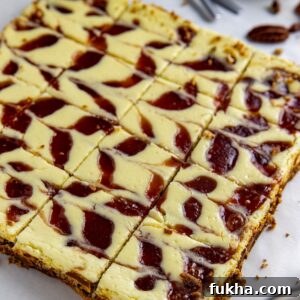 Baked and sliced keto cheesecake bars with sugar-free strawberry jam swirl.