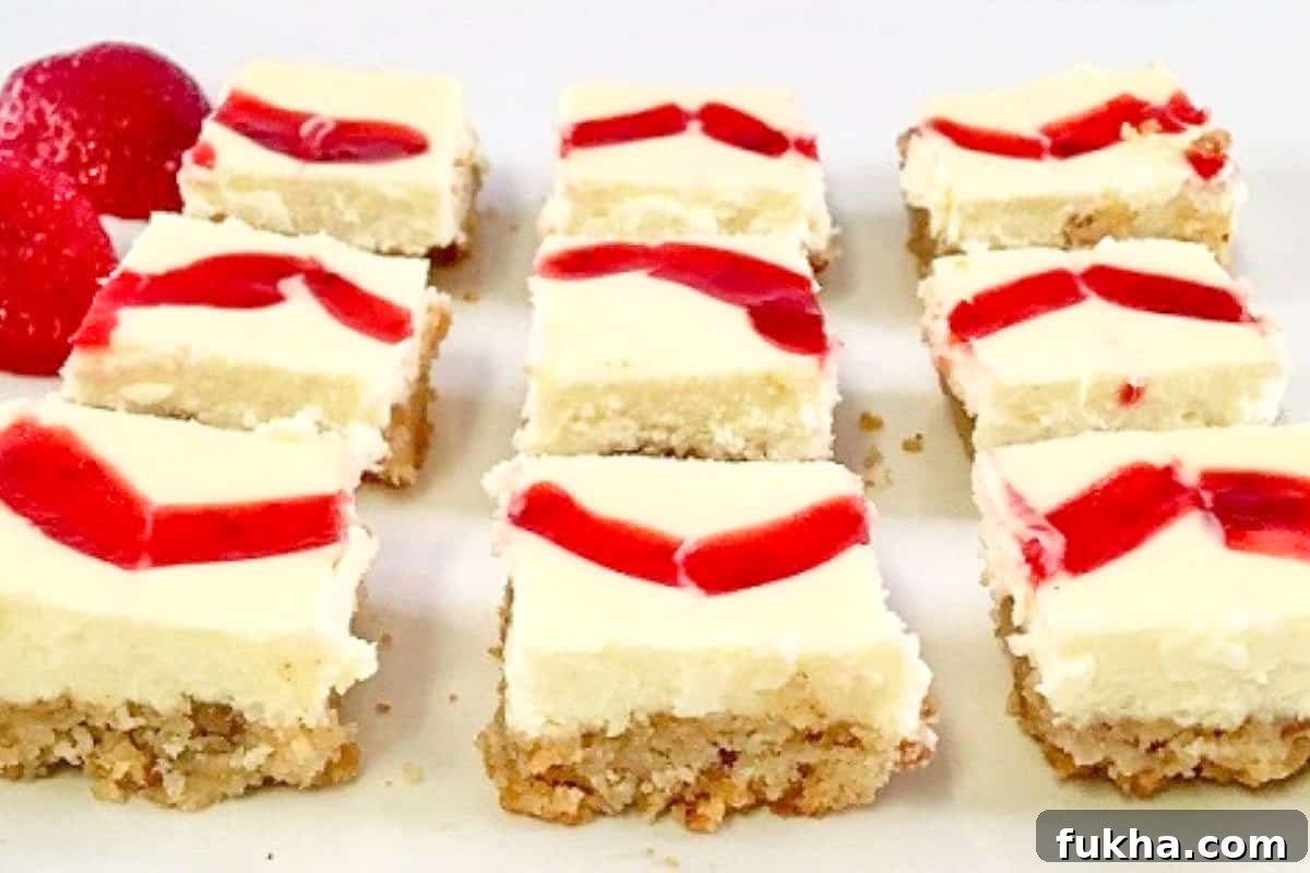 individual baked cheesecake squares with fresh strawberries in background