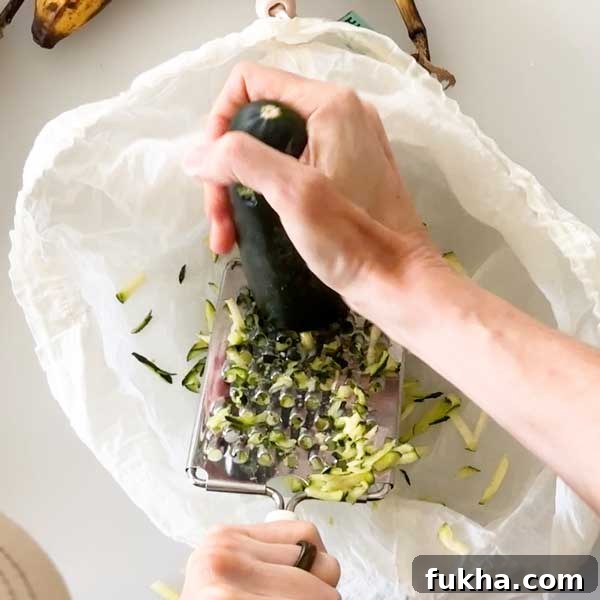 Fudgy Gluten Free Double Chocolate Zucchini Banana Muffins 5 Shredding zucchini into a mesh bag with a cheese shredder.