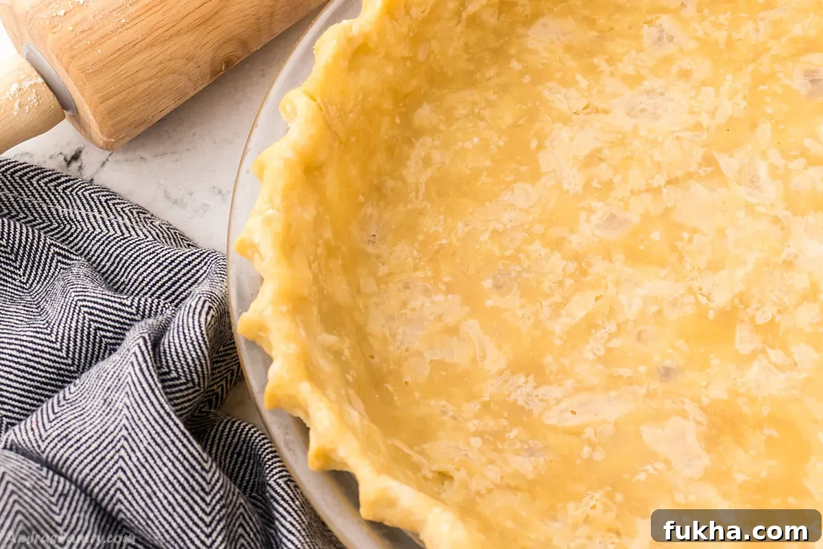 A close up look at the edges of a blind baked pie crust.