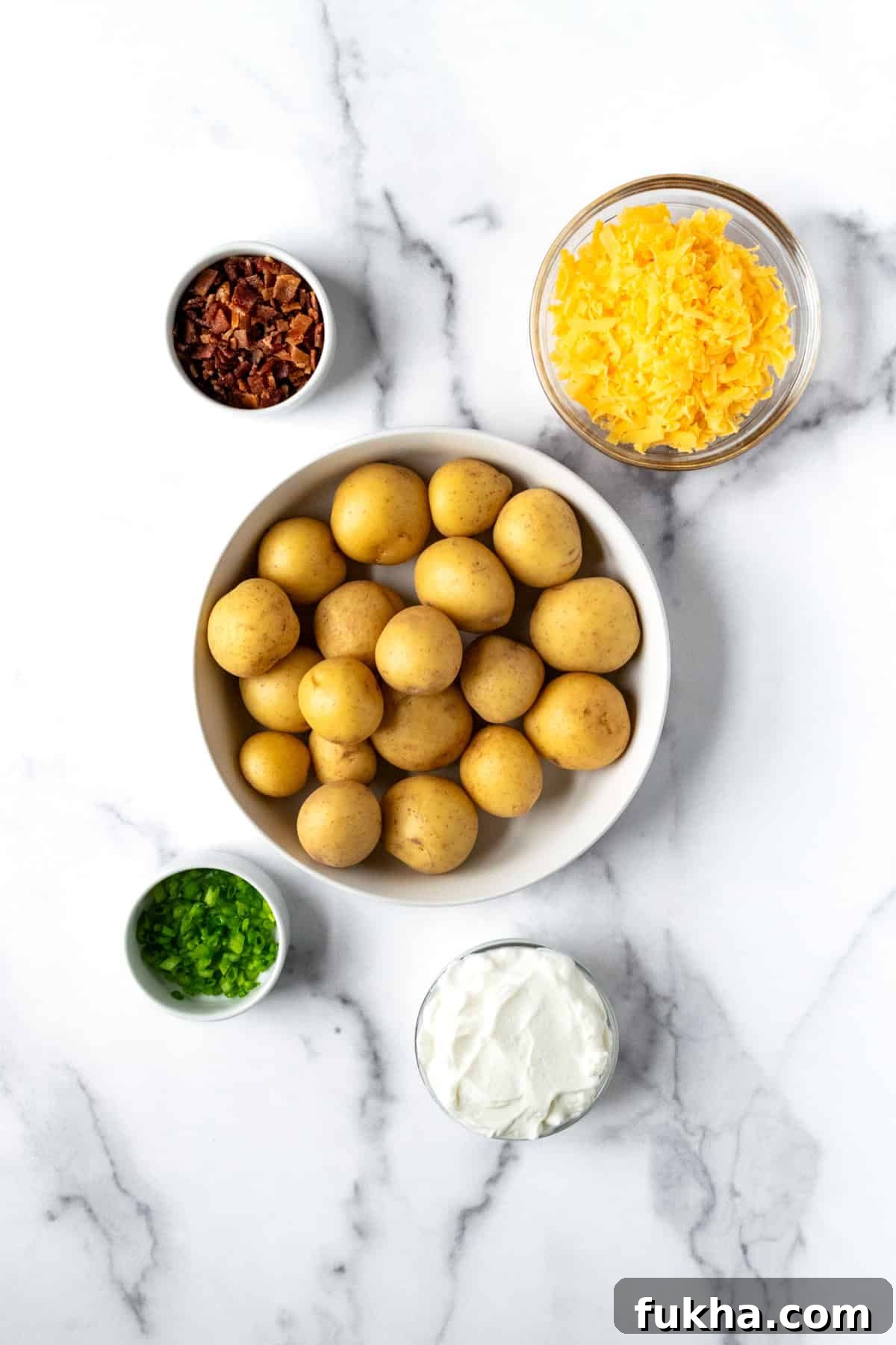 Crispy Baked Potato Bites with Cheddar and Herbs 3 Baked Potato Bites Ingredients on a marble countertop.