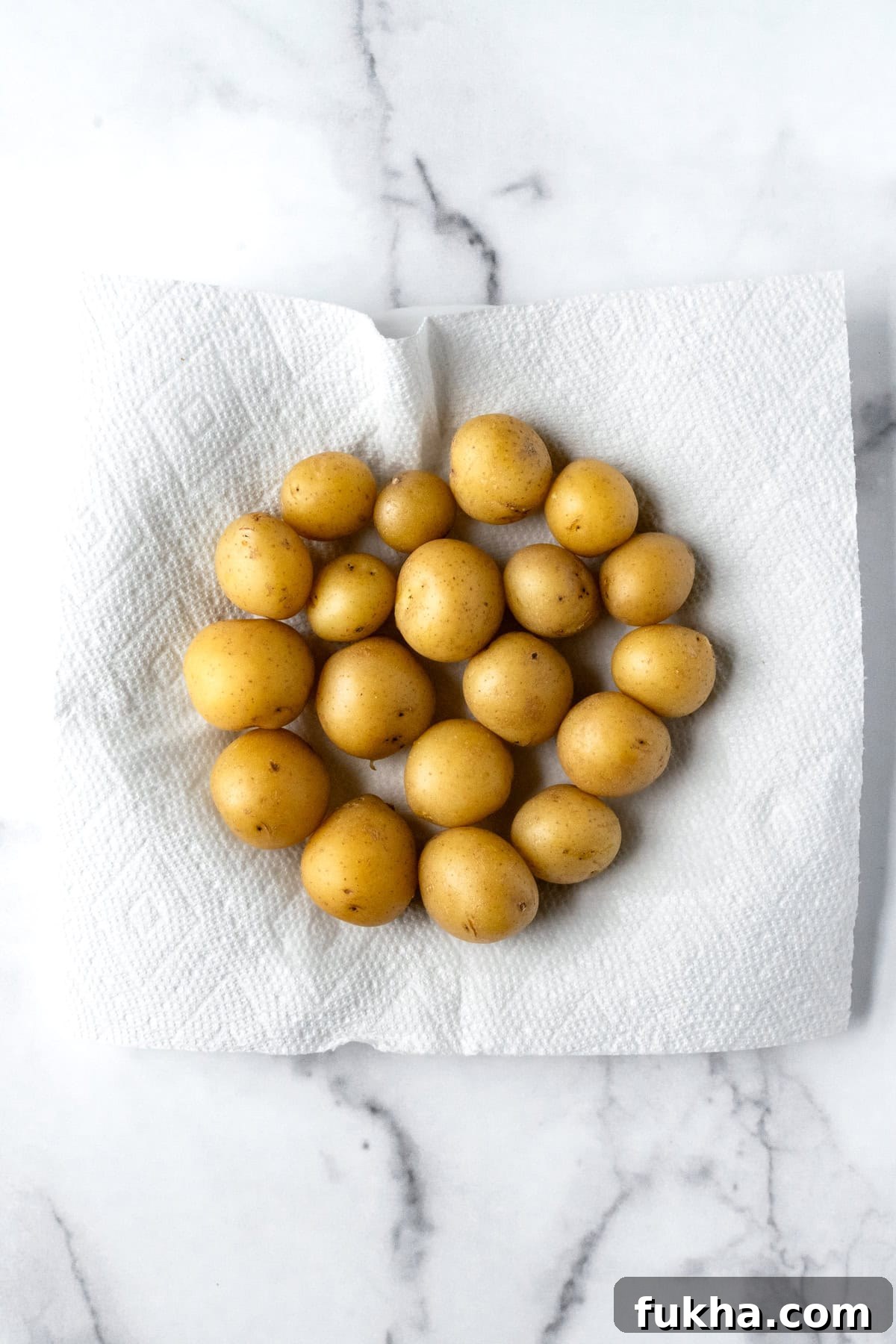 Crispy Baked Potato Bites with Cheddar and Herbs 5 Boiled Mini Yellow Potatoes drying and cooling on a paper towel.