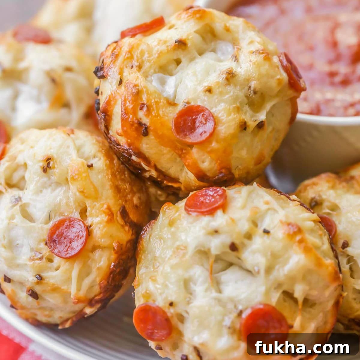 Pepperoni pizza muffins served with a side of marinara.