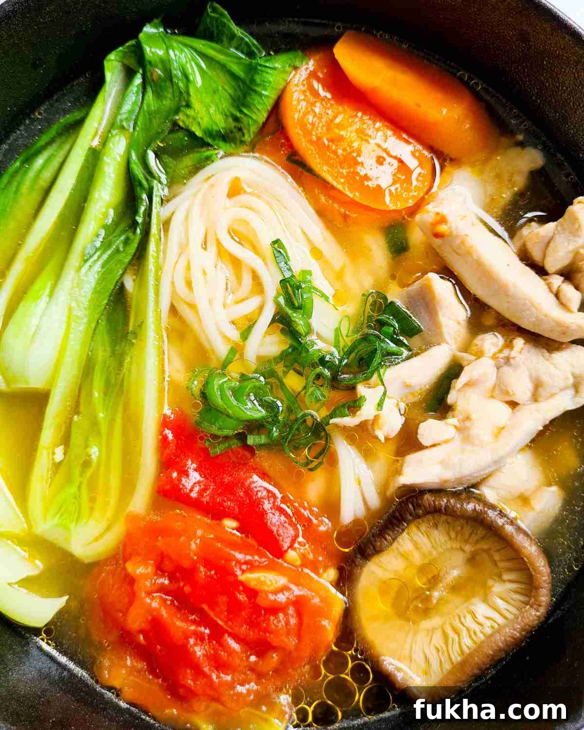 Close up of a bowl of noodle soup with vegetables