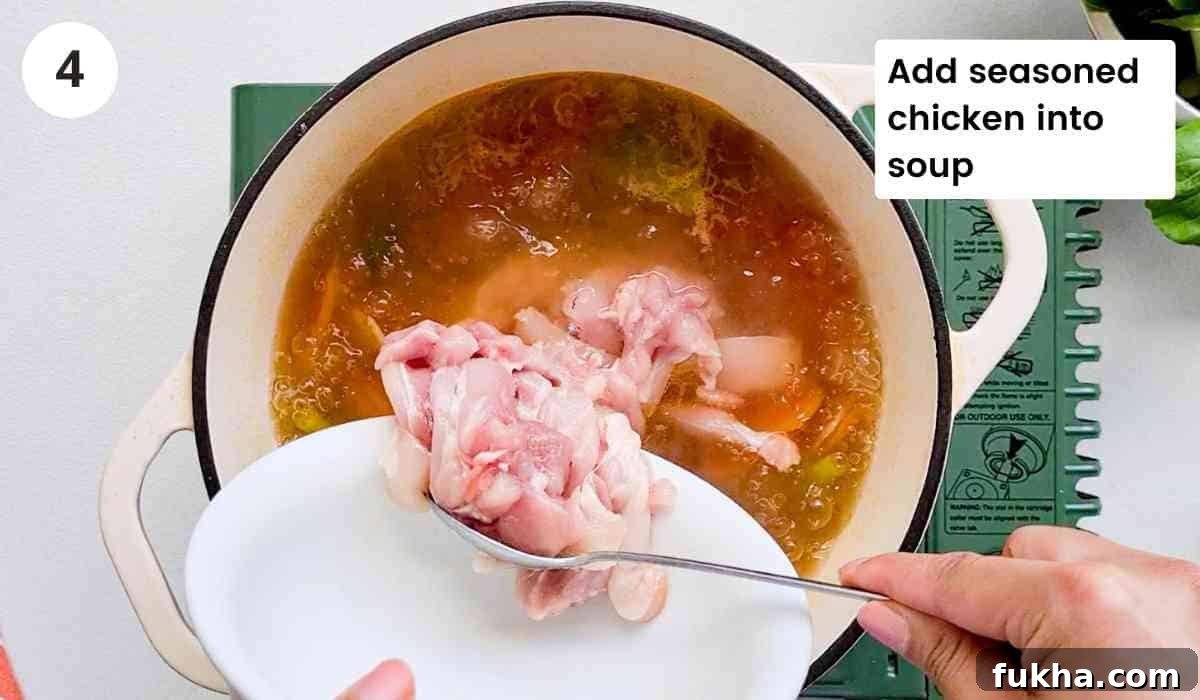 chicken being added into boiling soup