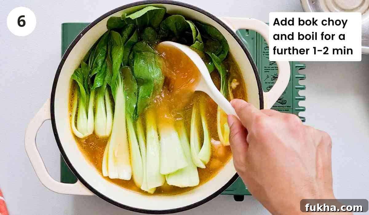 bok choy being added into a pot of soup
