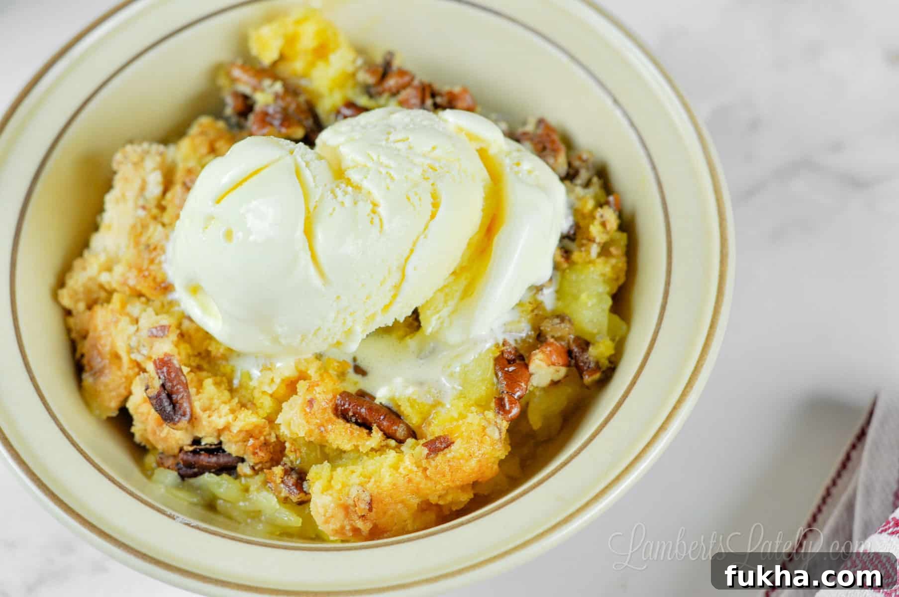bowl of pineapple dump cake with ice cream.