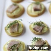 A close up of pickled herring bites topped with dill