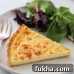 Close up of Swedish Cheese Pie (Västerbottenpaj) with a salad and fork.