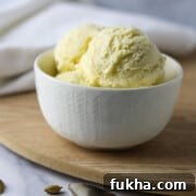 Cardamom Ice Cream in a white dish on a wooden surface.