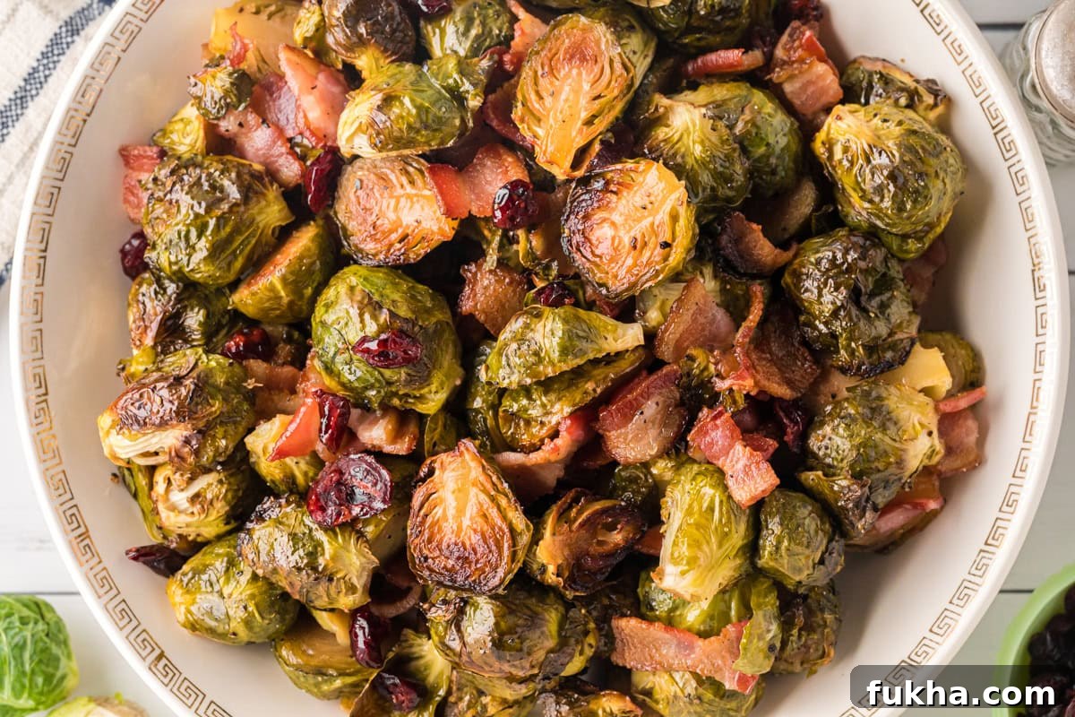 Overhead view of maple roasted brussels sprouts with bacon and cranberries.