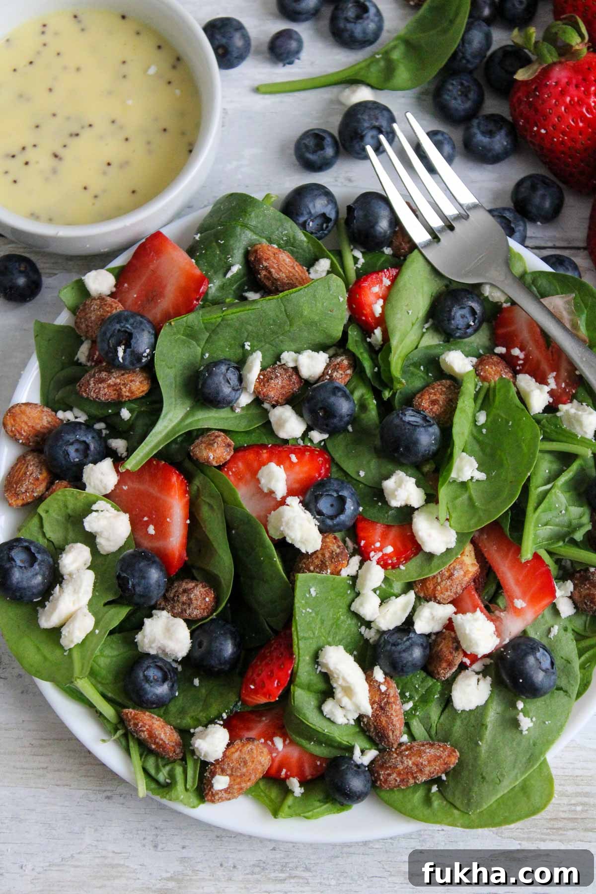 Blueberry salad with candied almonds topped with feta and strawberries and poppyseed dressing.