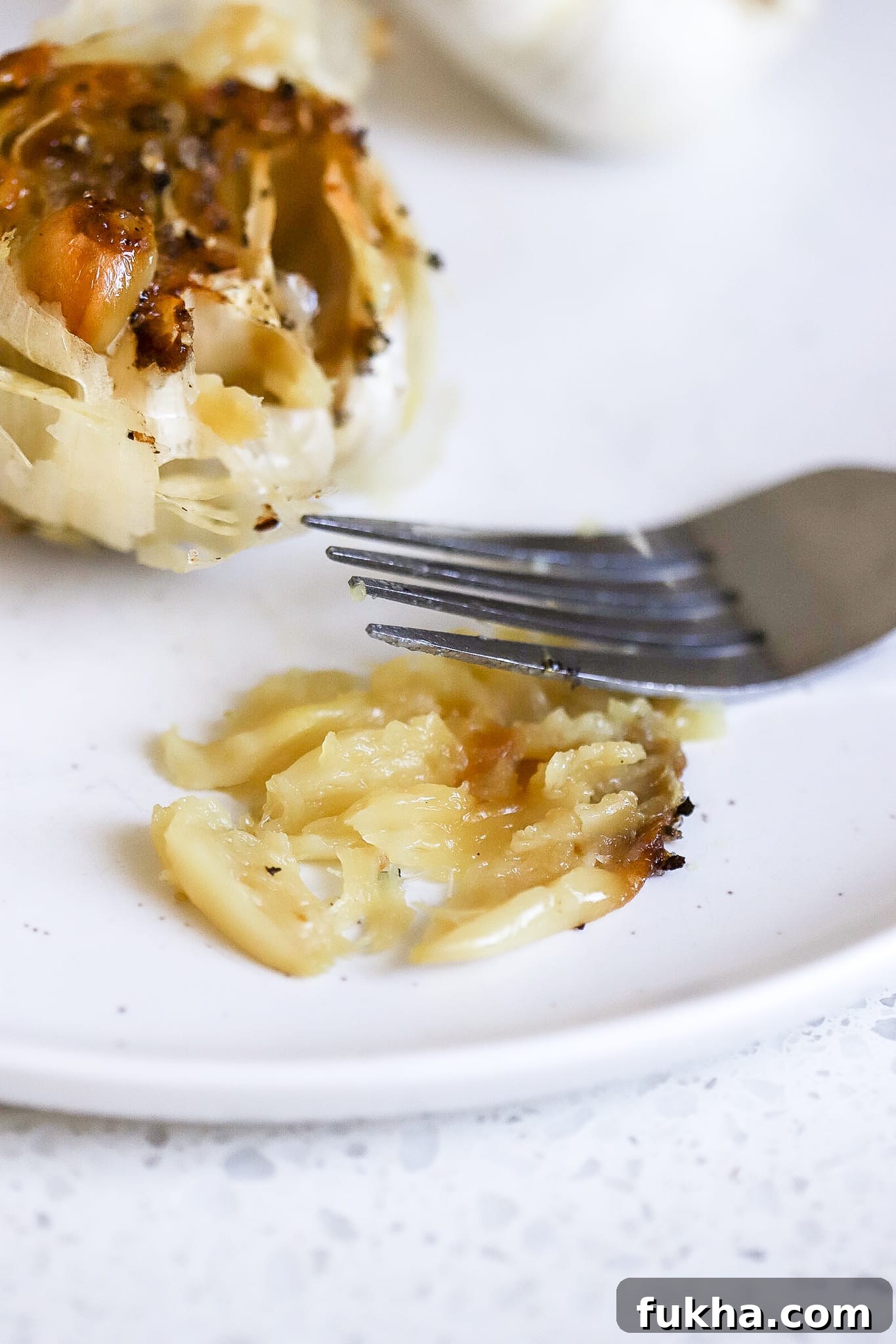 individual garlic clove mashed on a plate with a fork