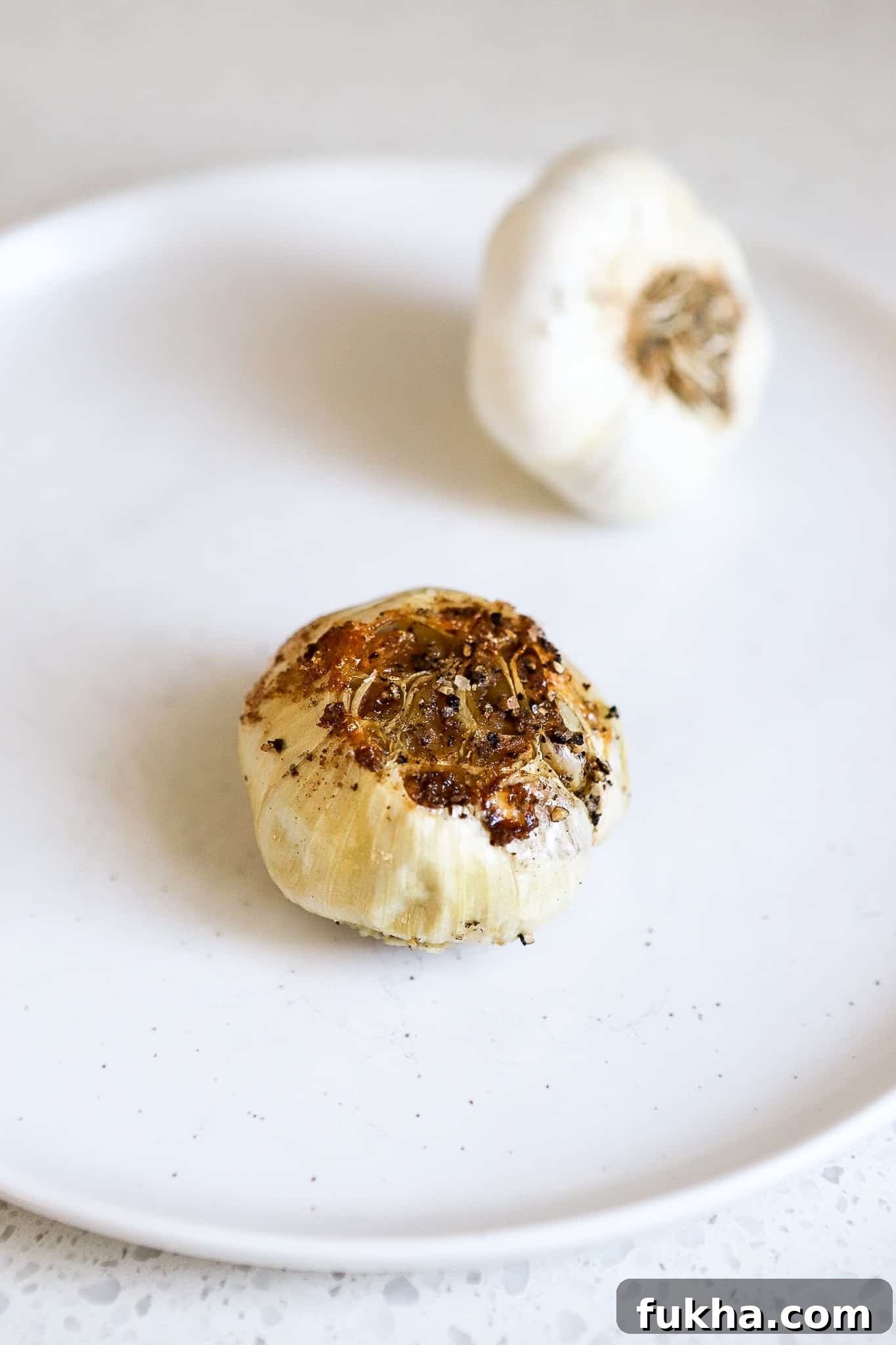 close up shot of whole garlic bulb fresh out of the air fryer